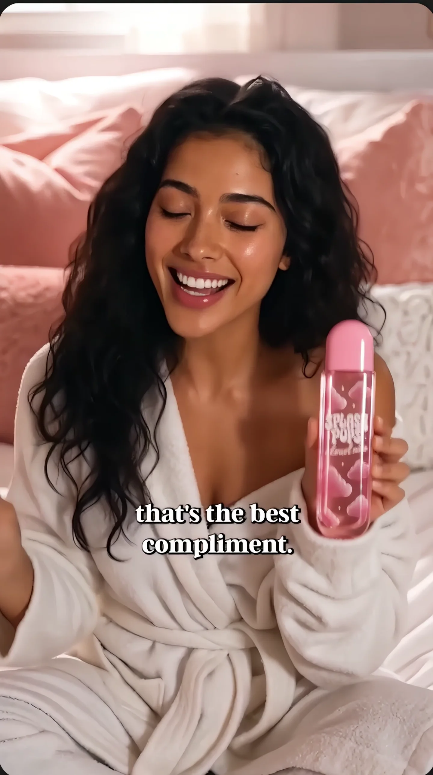 A creator in a white robe presents a pink Splash Pops fragrance bottle.