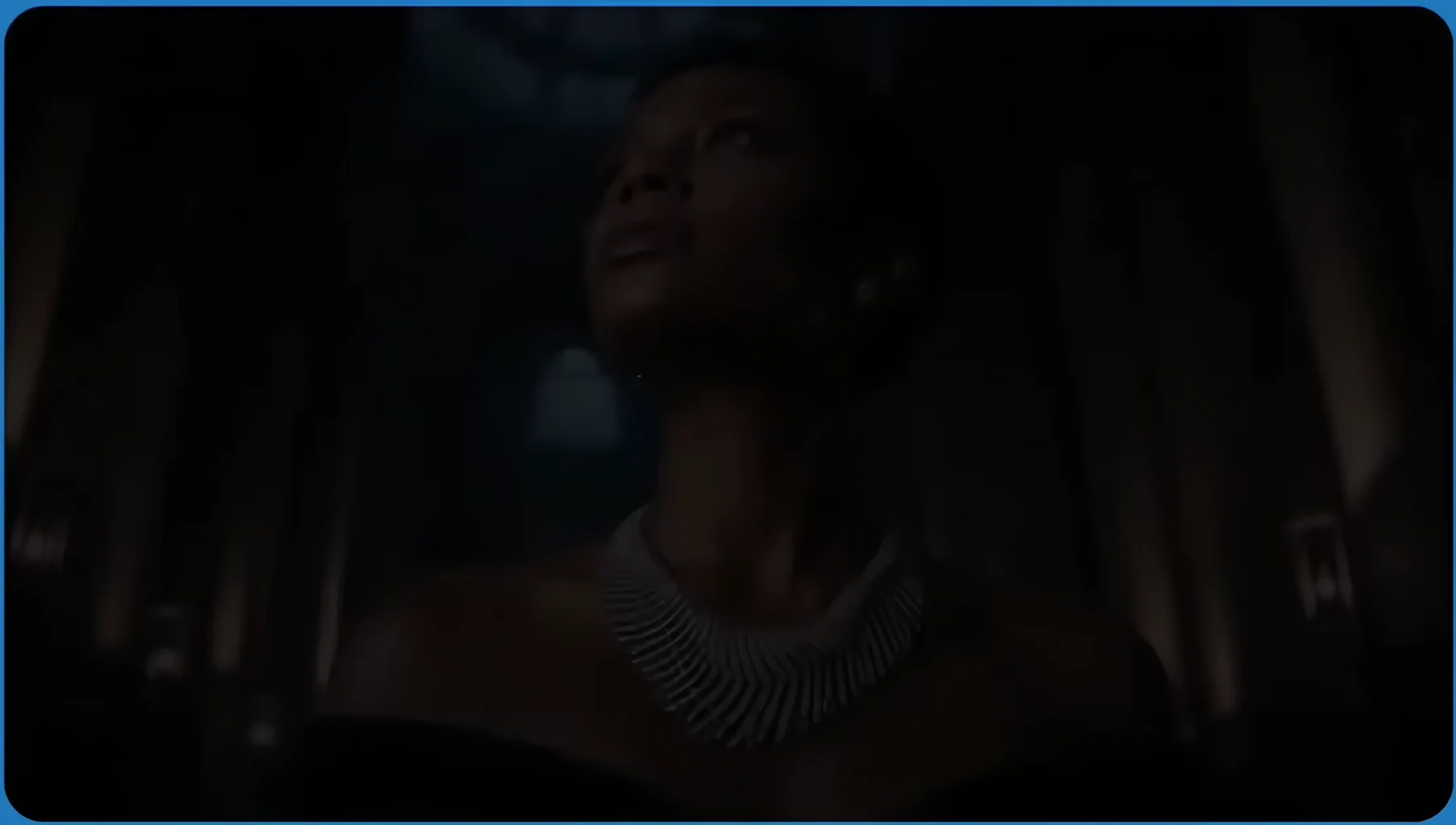 A woman wearing a diamond necklace in a cinematic, low-lit setting.