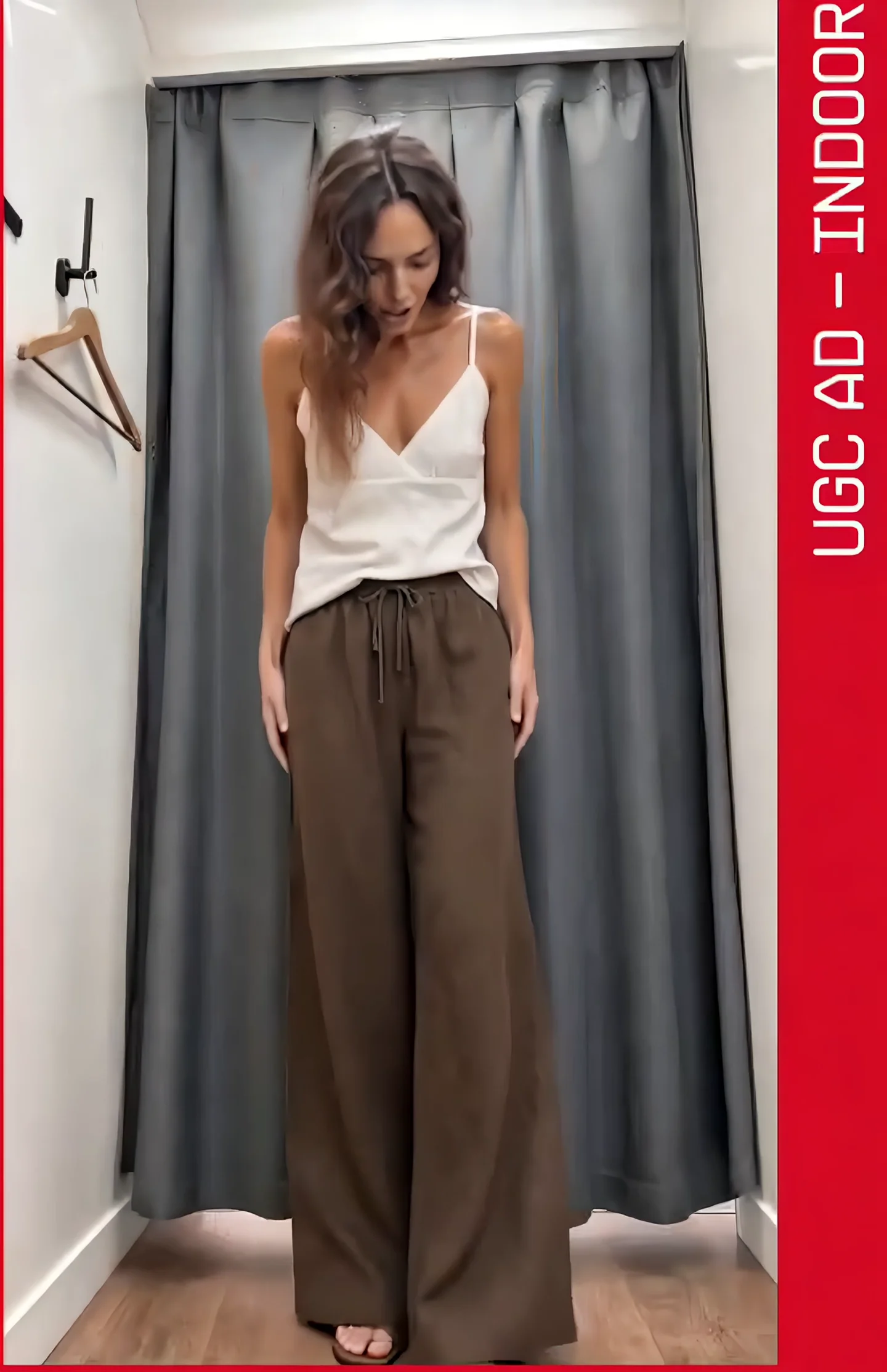 A UNIQLO indoor try-on featuring brown wide-leg trousers and a white camisole.